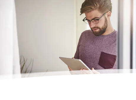 Mann arbeitet auf Tablet